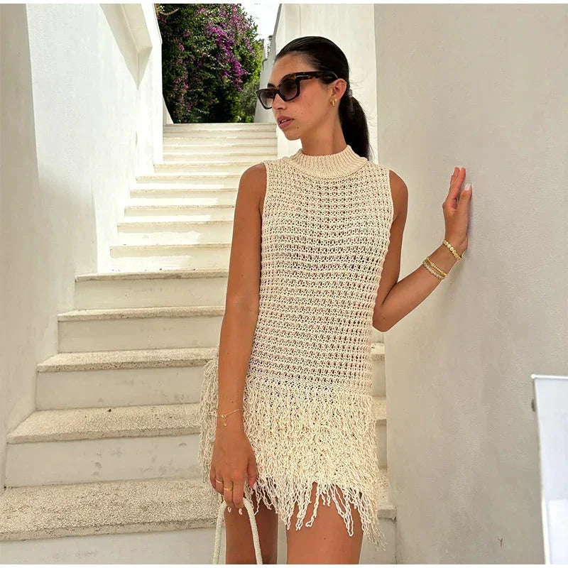 Ivory sleeveless knit dress with tassel details, perfect for casual or formal occasions.