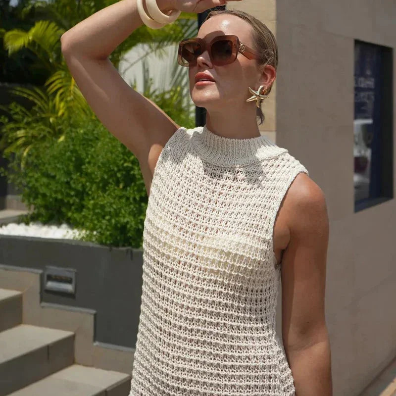 Sleeveless knit dress in ivory with tassel detail, perfect for a casual-chic look.