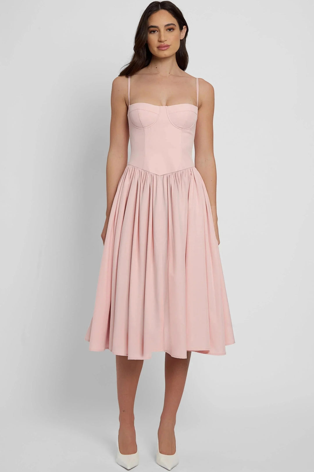 Pink mid-length bustier dress with pleated skirt in soft cotton blend fabric. Features a flattering silhouette with a…
