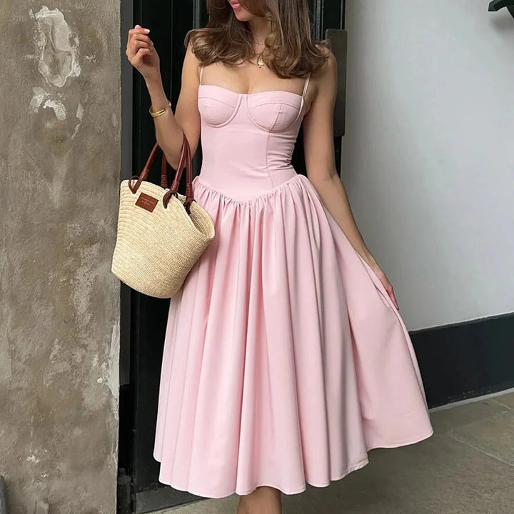 Pink mid-length bustier dress with pleated skirt, perfect for a chic look. Soft fabric and flattering design for a stylish…