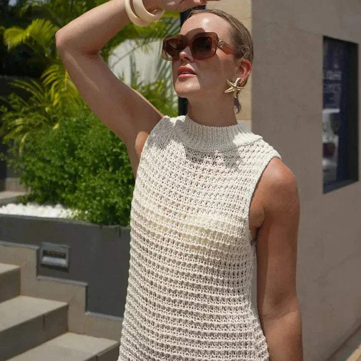 Ivory sleeveless ankle-length dress with tassels, elegant design with textured fabric and subtle detailing on the tassels.