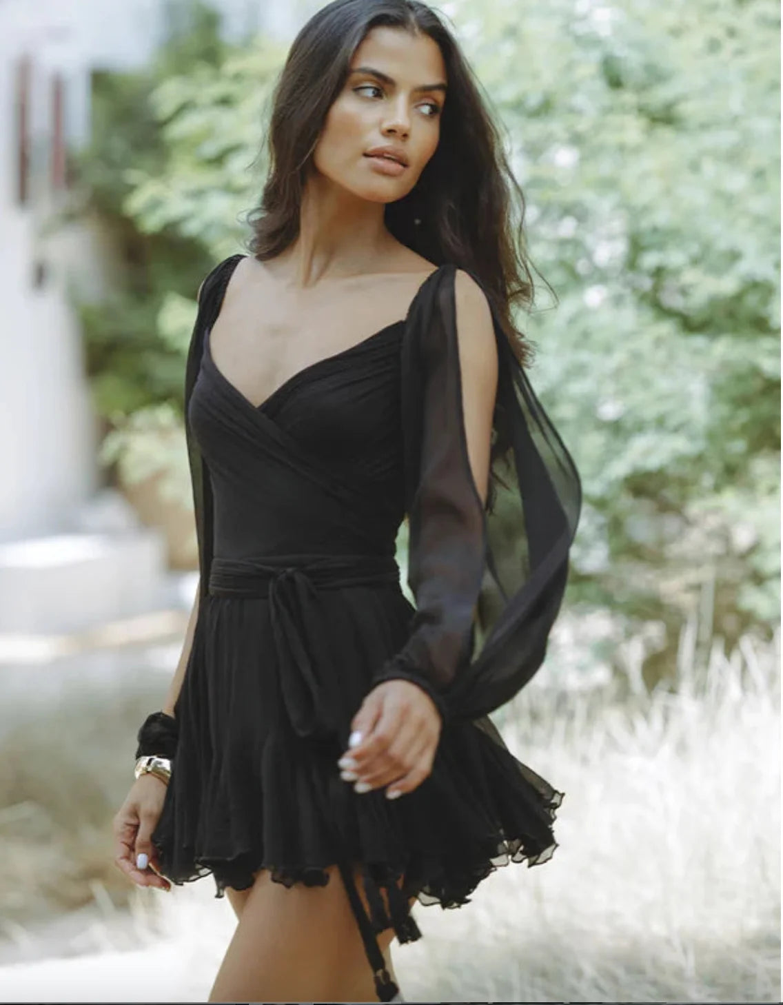 "Black mini dress with ruffled hem, draping elegantly. Made of soft fabric, perfect for night out or special occasions."