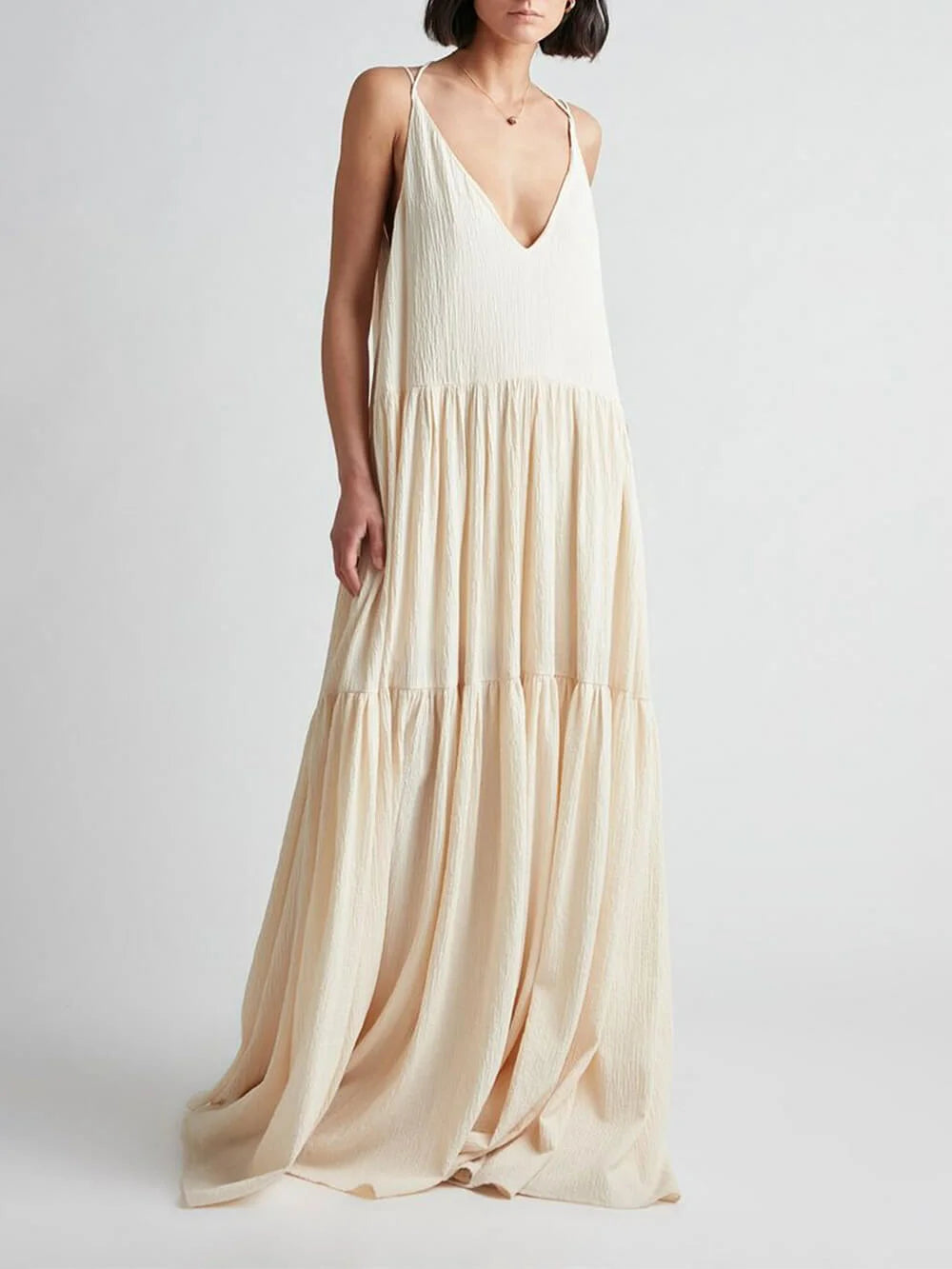 Cream V-neck maxi dress with tiered skirt in Sand. Features soft, flowy fabric ideal for effortless summer style.