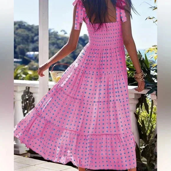 "Women's pink patterned maxi dress with tie straps, featuring a delicate floral design on soft, flowy fabric."
