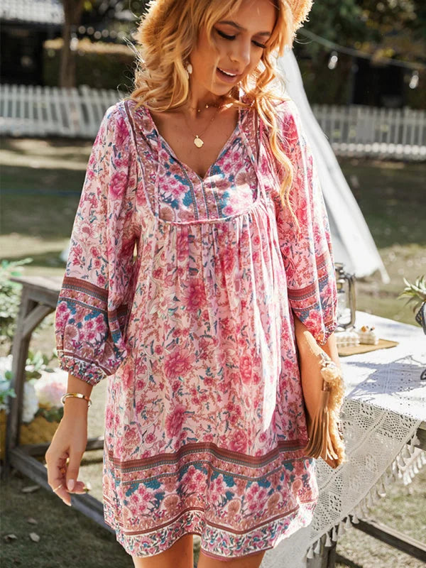 Bohemian mini dress featuring flowy silhouette, adorned with intricate floral patterns on a lightweight fabric.