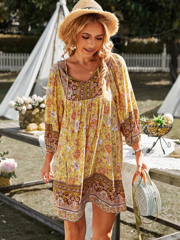 Flowy bohemian mini dress in Neveah with floral patterns, perfect for a breezy day.