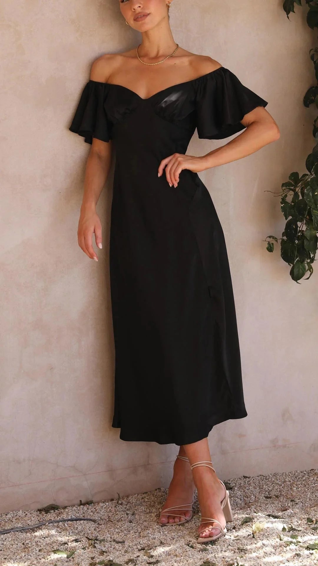 Off-shoulder maxi dress in black, featuring elegant slits. Made with soft and flowy fabric, perfect for a chic and stylish…