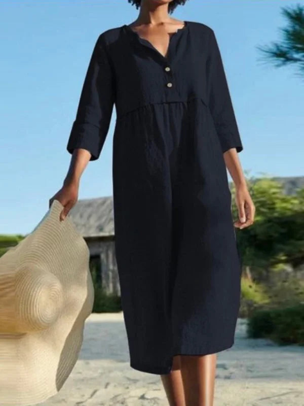 Black Nori midi dress with button-up front and practical pockets, made of lightweight and breathable fabric for everyday…