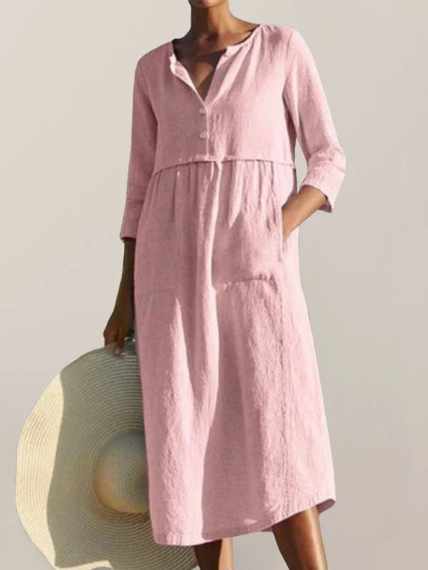 Pink button-up midi dress made of comfortable fabric with functional pockets. Perfect for casual or dressed-up looks.