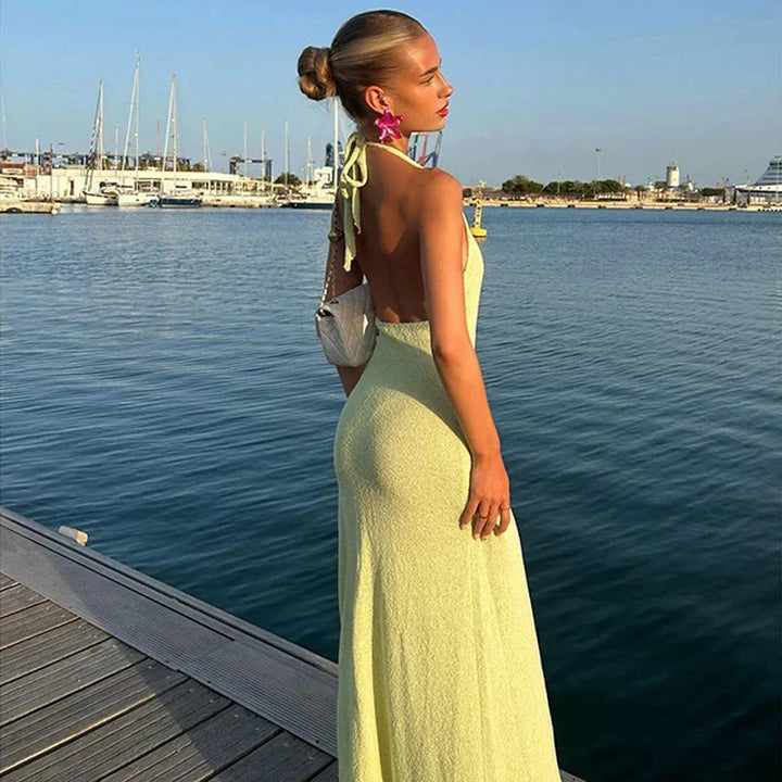 "Perri halter neck maxi dress, showcasing elegant side slit. Made of soft and flowing fabric in a stylish and versatile…