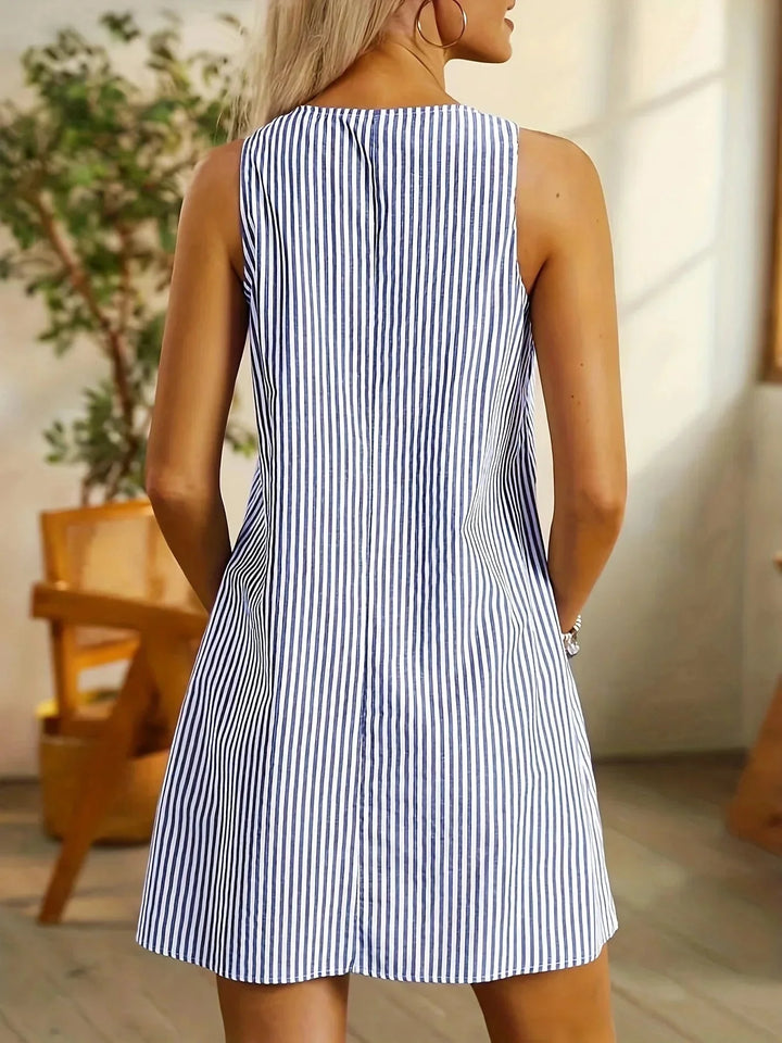 Sleeveless striped dress in black and white, with buttons, pockets, and a comfortable cotton fabric.