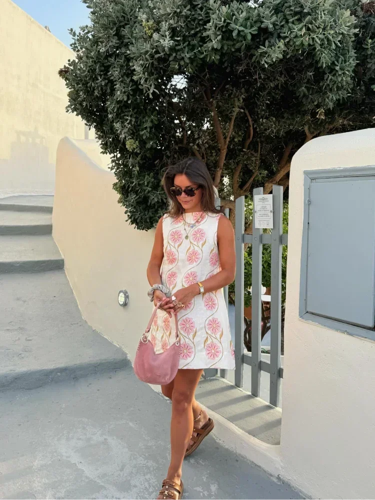 "Women's pink floral sleeveless dress in soft cotton blend, featuring vibrant floral print. Perfect for a sunny day out."