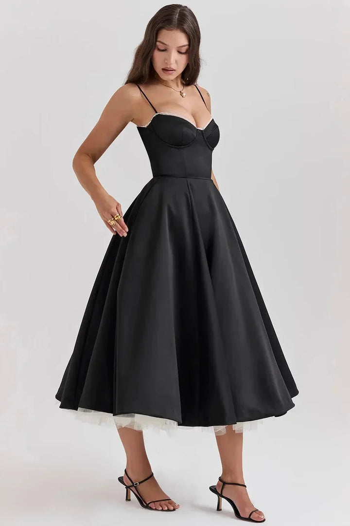 Black satin dress with cream tulle hem, perfect for a special occasion. Features a flattering design with a touch of…