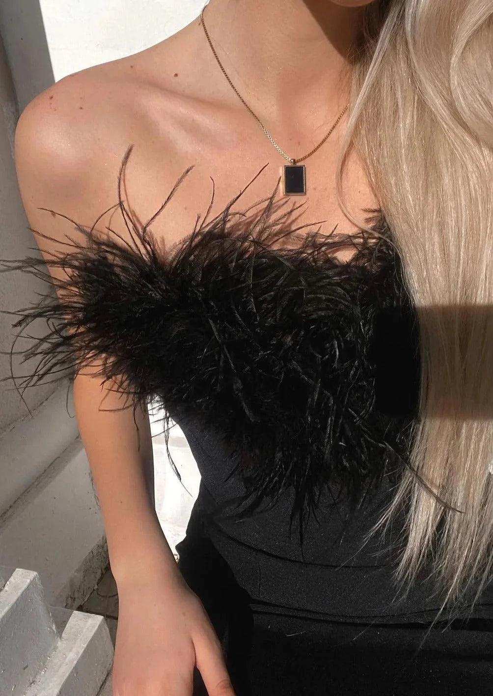 Women's black feather-detail strapless maxi dress with sleek silhouette.