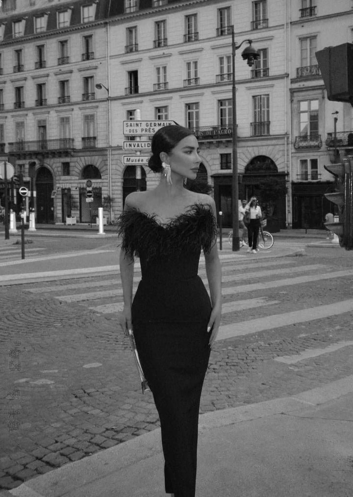 "Black strapless maxi dress with feather detailing for women, elegant and sleek design, perfect for special occasions and…