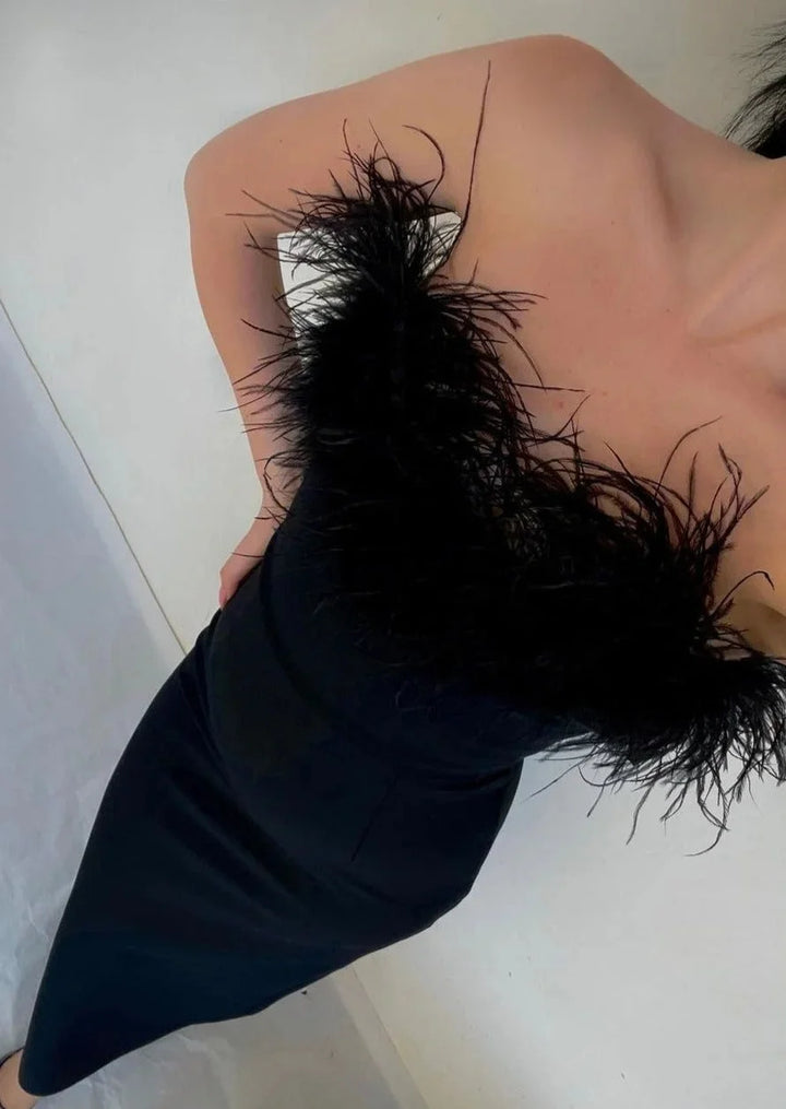 Women's black strapless maxi dress with feather details, sleek and elegant design, perfect for special occasions.