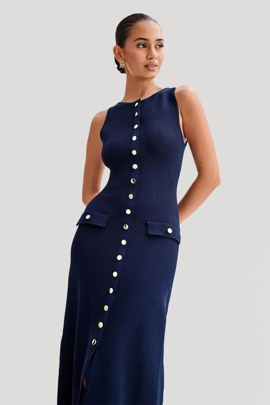 Sleeveless dress in navy blue with front button detailing and a tailored fit, perfect for a chic and sophisticated look.