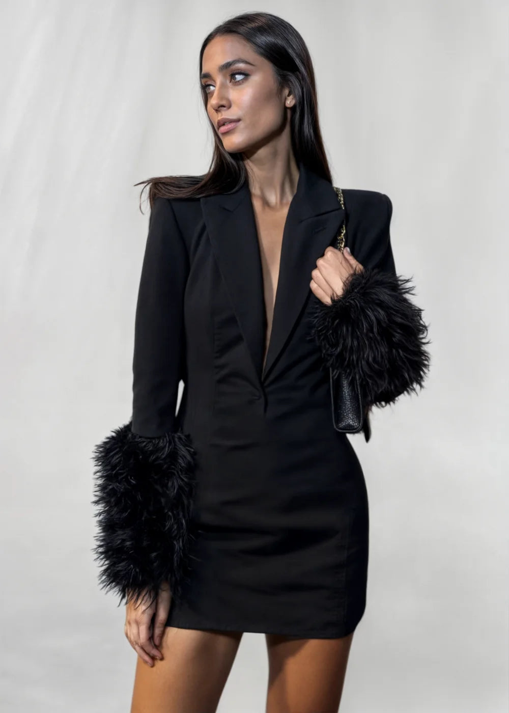 Black mini dress with dramatic fur sleeves, perfect for a chic and daring look. Ideal for a statement outfit at any event.