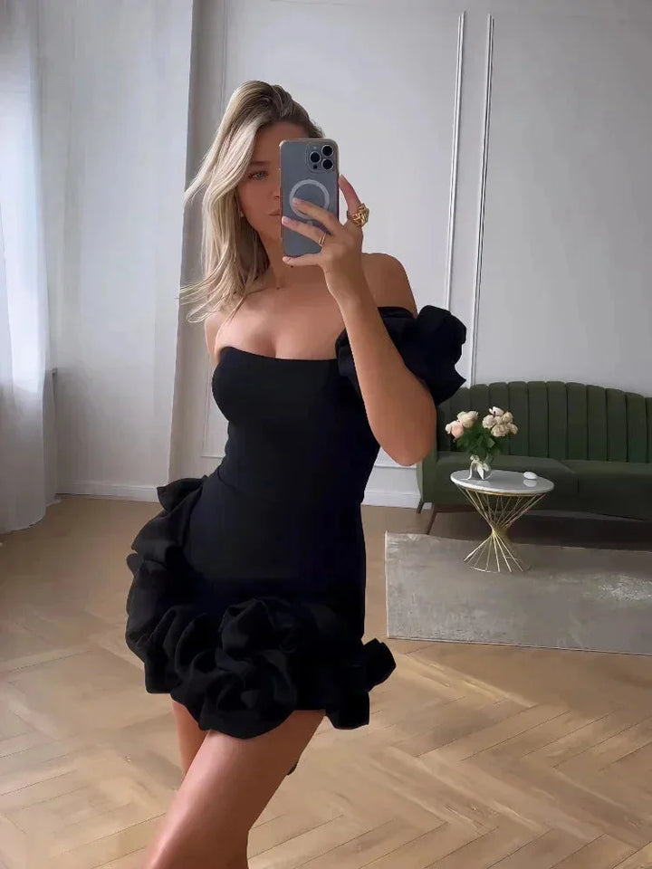 Strapless midi dress in navy blue with exaggerated ruffles and side slit, perfect for a summer evening outing.