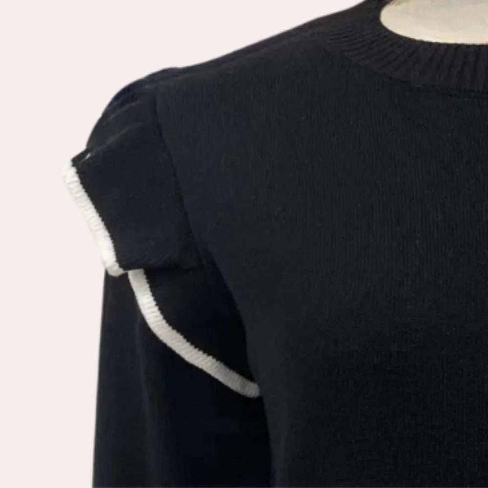 Black sweater with ruffle detailing, perfect for a chic look. Made of soft knit material with a modern and feminine design.