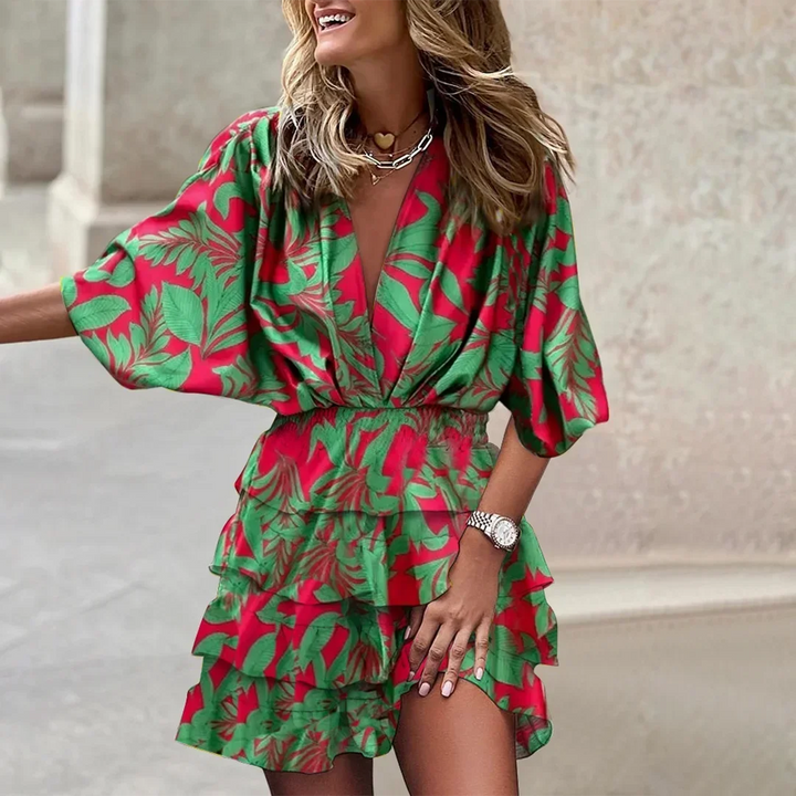 Green floral wrap dress with flared sleeves, ideal for summer, made of lightweight and breathable fabric.